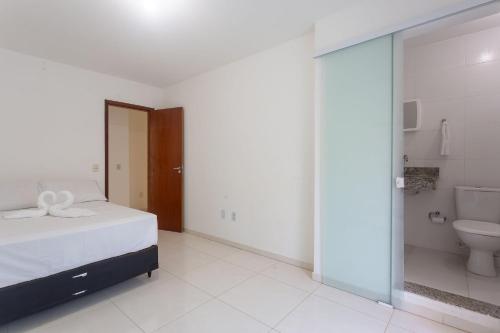 um quarto com uma cama e uma casa de banho com um WC em Sobrado a 300m da praia de Ilhéus VCM005 em Ilhéus