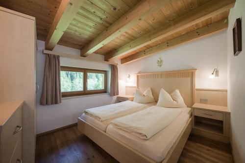 ein Schlafzimmer mit einem großen weißen Bett in einem Zimmer in der Unterkunft Residence Reisenschuh in Sterzing