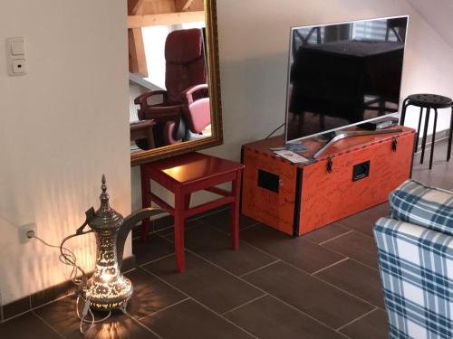 a living room with a dresser and a mirror at DEOSAI Apartment Kelkheim in Kelkheim