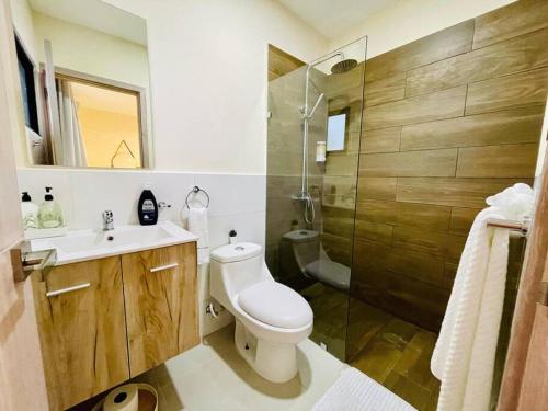 uma casa de banho com um WC, um lavatório e um chuveiro em Downtown Punta Cana Villa em Punta Cana