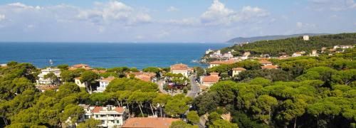 a town on a hill next to the ocean at Castiglioncello Suite in Castiglioncello