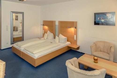 a bedroom with a large bed and a table and chairs at Apartmenthaus SportCHALET in Bad Dürrheim