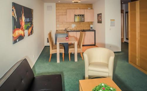 a living room with a couch and a table and chairs at Apartmenthaus SportCHALET in Bad Dürrheim