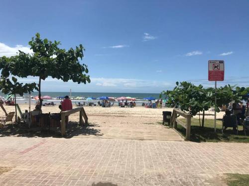 a person sitting on a bench at the beach at Apto com ótima localização, centro de Meia Praia in Itapema