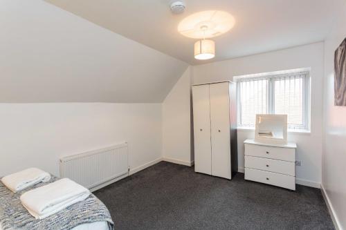 a white bedroom with a bed and a mirror at Cherry Property - Blueberry Suite in Blackpool