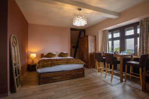 een slaapkamer met een bed en een tafel en stoelen bij La haut in Saverne