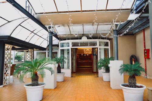 a lobby with palm trees inront of a building at Hotel Max in Aversa