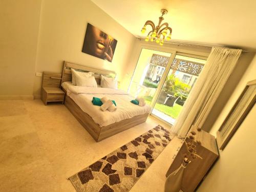 a bedroom with a bed and a large window at Fabulous Sea view 1 BR & private Garden to the pool at Mangroovy in Hurghada