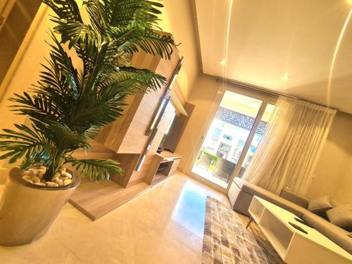 ein Wohnzimmer mit einer Topfpflanze und einem Fenster in der Unterkunft Fabulous Sea view 1 BR & private Garden to the pool at Mangroovy in Hurghada