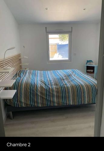 - une chambre avec un lit, une fenêtre et un bureau dans l'établissement Biscarrosse Lac Maison au bord du canal pour 6 ou 7 personnes, à Biscarrosse