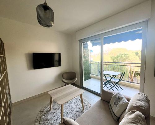 Il comprend un salon avec un canapé, une télévision et un balcon. dans l'établissement Casa JONA, à Cagnes-sur-Mer