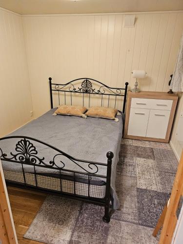 um quarto com uma cama preta com duas almofadas em Cozy home em Gravdal