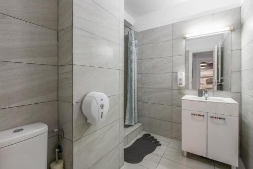 a bathroom with a toilet and a sink and a mirror at Bucharest Central Apartments - Shabbat Friendly in Bucharest