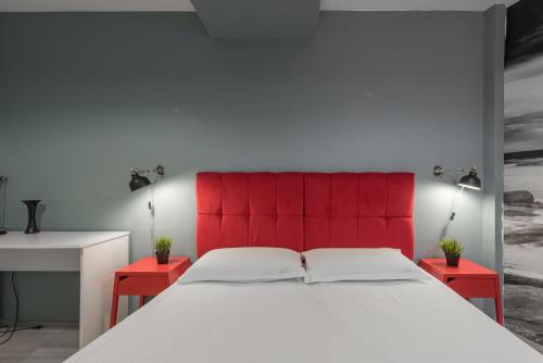 a bedroom with a red headboard and a white bed at Bucharest Central Apartments - Shabbat Friendly in Bucharest