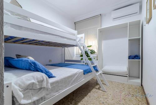 a bedroom with two bunk beds and a ladder at Chalet a pie de playa in Punta Umbría