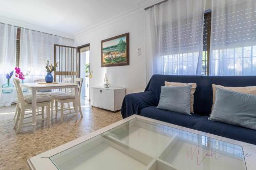 a living room with a blue couch and a table at Chalet a pie de playa in Punta Umbría