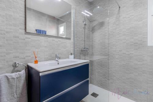 La salle de bains est pourvue d'un lavabo bleu et d'une douche. dans l'établissement Chalet a pie de playa, à Punta Umbría