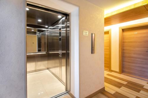 eine Glastür zu einer ebenerdigen Dusche in einem Zimmer in der Unterkunft Orbi Palace Bakuriani 101 in Bakuriani