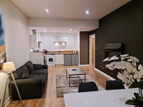 a living room with a couch and a table at VCity ApartHotels Glasgow Central in Glasgow