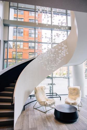 a lobby with two chairs and a chandelier at Le Meridien Denver Downtown in Denver