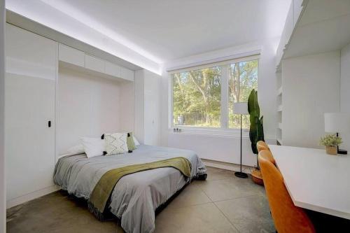 ein weißes Schlafzimmer mit einem Bett und einem Fenster in der Unterkunft KCM Tremont Oaks Apartments 3 in Cleveland