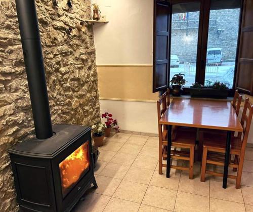 a stove in a room with a wooden table and a tableablish at Hotel D` Ares in Ares del Maestre