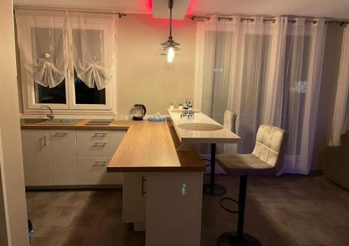 une cuisine avec une table et des chaises. dans l'établissement Love Room & Spa Jacuzzi, à Fleury-les-Aubrais
