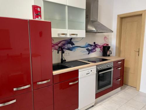 a kitchen with red cabinets and a red refrigerator at Ferienhaus Lichtenberg in Herleshausen