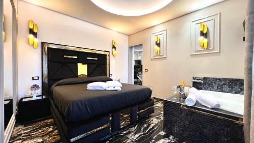 um quarto com uma cama grande e uma banheira em Black Suite Hydro em Montecatini Terme