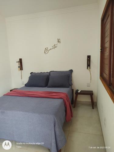 a bedroom with a bed with a red and blue blanket at Pousada Bonita do Gostoso in São Miguel do Gostoso