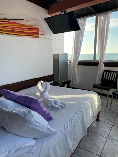 a bedroom with a bed with two swans on it at Hotel La Barca in Atacames