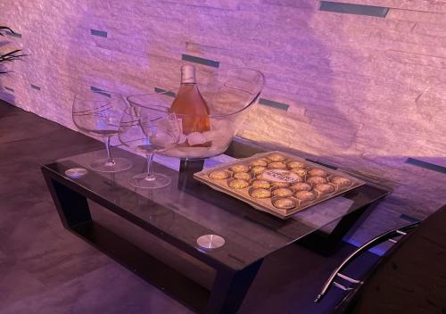 stół z dwoma kieliszkami wina i tacą pączków w obiekcie Love Room & Spa Jacuzzi w mieście Fleury-les-Aubrais