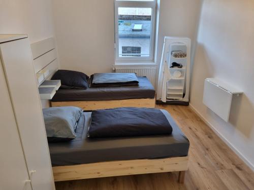 Duas camas num pequeno quarto com uma janela em City Central Apartment House em Kaiserslautern