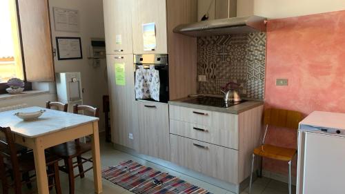 una cucina con tavolo e una piccola cucina con piano cottura di Casa di Chiara a Crotone
