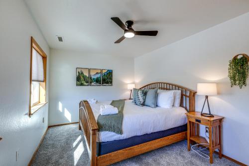 Spacious Flagstaff Home with Private Hot Tub and Deck! في فلاغستاف: غرفة نوم بسرير ومروحة سقف