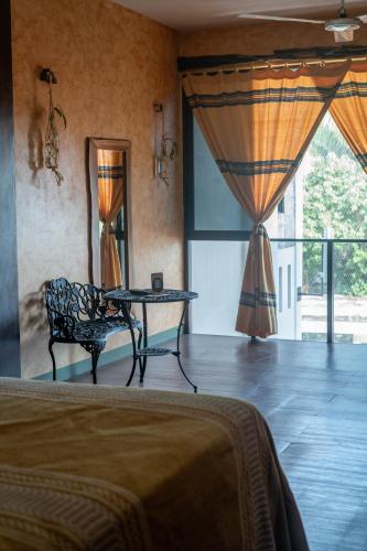 a bedroom with a table and a chair and a bed at Madre Tierra Hotel & Coworking in Puerto Escondido
