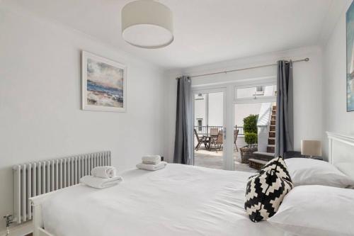 a bedroom with a white bed with two towels on it at Stunning Property Seaviews, Private Pool & Parking in Saundersfoot