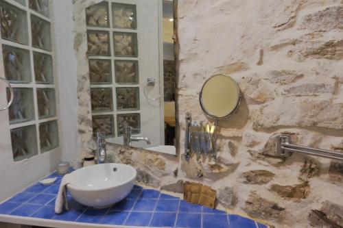 a bathroom with a sink and a mirror at La maisonnette avec SPA, PISCINE et CLIMATISATION in Sainte-Vallière