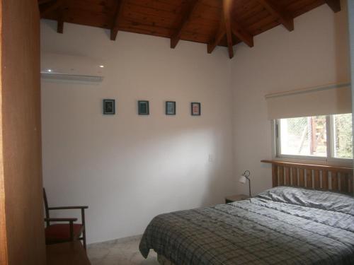 1 dormitorio con cama y ventana en Vacaciones en Belgrano IG en Villa General Belgrano