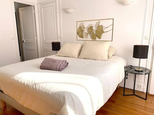 - un lit blanc dans une chambre avec deux lampes dans l'établissement Mytripinparis - Large and Sunbathed 1Br - close to the Eiffel Tower, à Paris