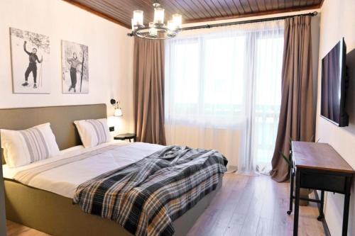 a bedroom with a bed and a desk and a window at Marand Boutique Apartments in Bansko