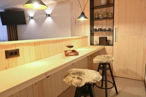 eine Küche mit einer Theke mit zwei Hockern an einer Bar in der Unterkunft Marand Boutique Apartments in Bansko