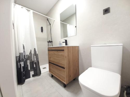 y baño con aseo, lavabo y ducha. en Apartamentos céntricos a 10 min de la playa, en Almería
