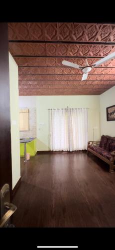 une chambre vide avec un canapé et un ventilateur de plafond dans l'établissement Sai, à Ambātturai
