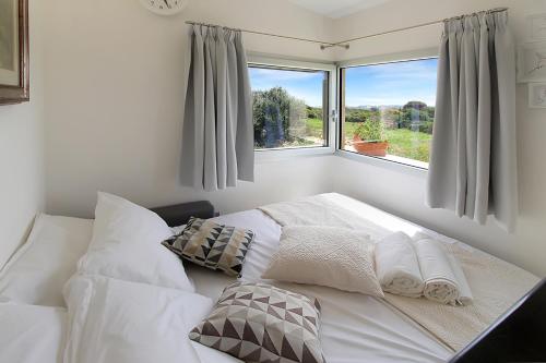 a white bed in a room with a window at Villa Magdala in La Maddalena