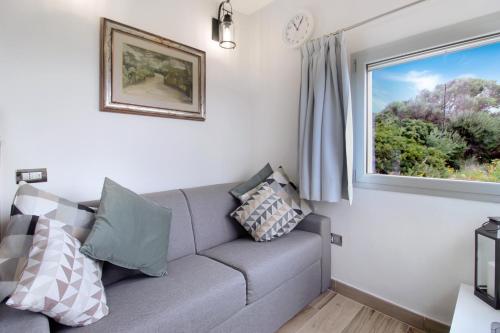a living room with a couch and a window at Villa Magdala in La Maddalena