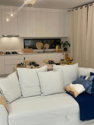 Ocean View Santa Filomena في منديلو: أريكة بيضاء مع وسائد في المطبخ