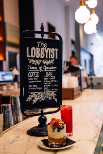 a sign on a counter with a pastry and a drink at Le Meridien Denver Downtown in Denver