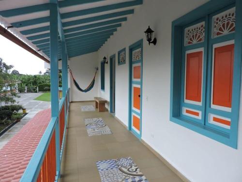 a hallway of a house with blue and orange doors at Finca Hotel Valparaíso in Armenia