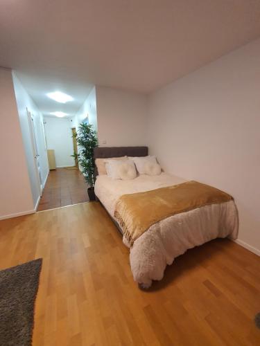 a bedroom with a large bed with a wooden floor at Close to the subway. Beautiful and Cozy apartment! in Stockholm